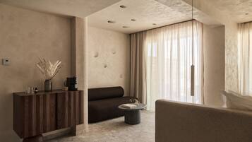 A modern living room with a sofa, a coffee table, a wooden cabinet, and a vase with dried plants.