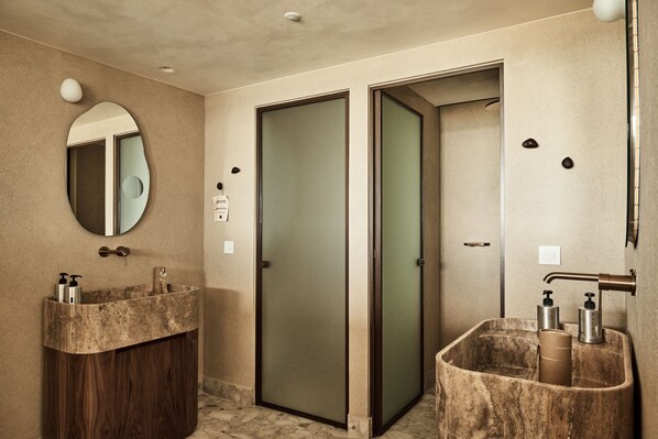 A bathroom with two sinks, a mirror, and a door.