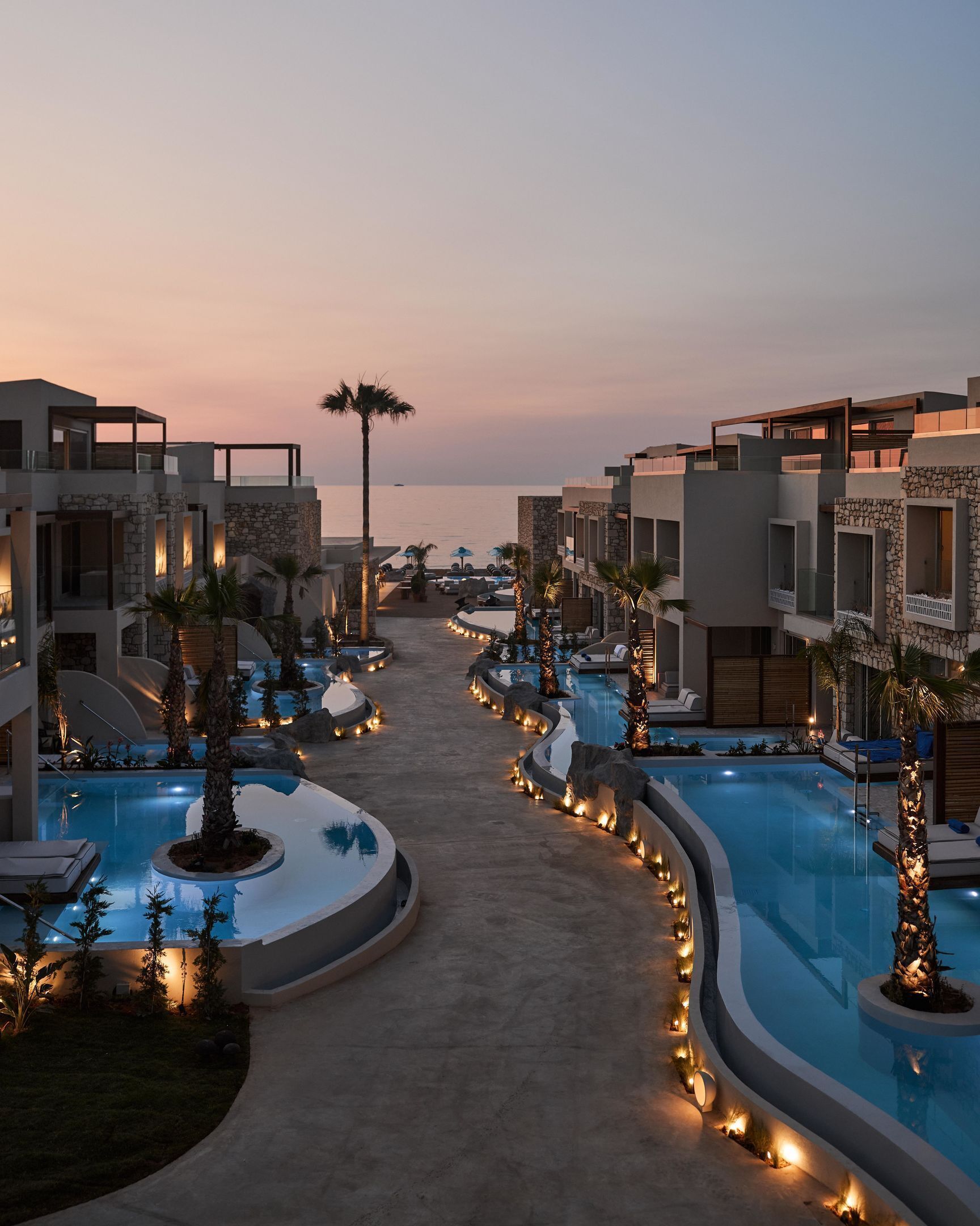 A resort with multiple swimming pools, palm trees, and modern architecture.