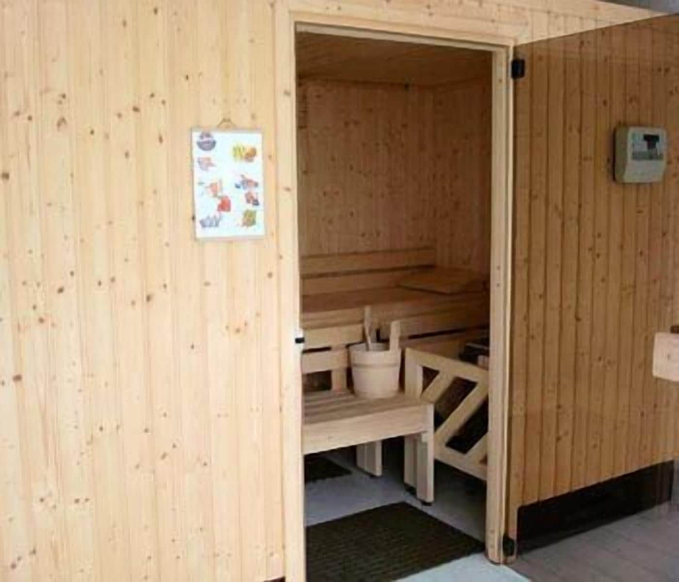 Una sauna de madera con un banco y una pequeña mesa.