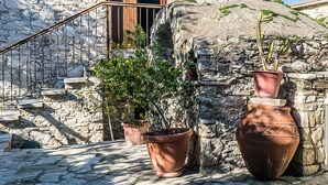 A stone building with a wooden staircase and potted plants.