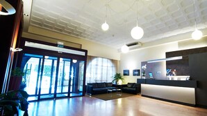 A modern reception area with a reception desk, seating area, and large windows allowing natural light.