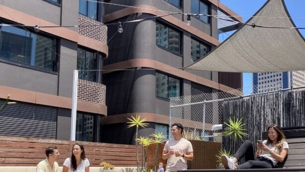 An outdoor seating area with a modern building in the background.