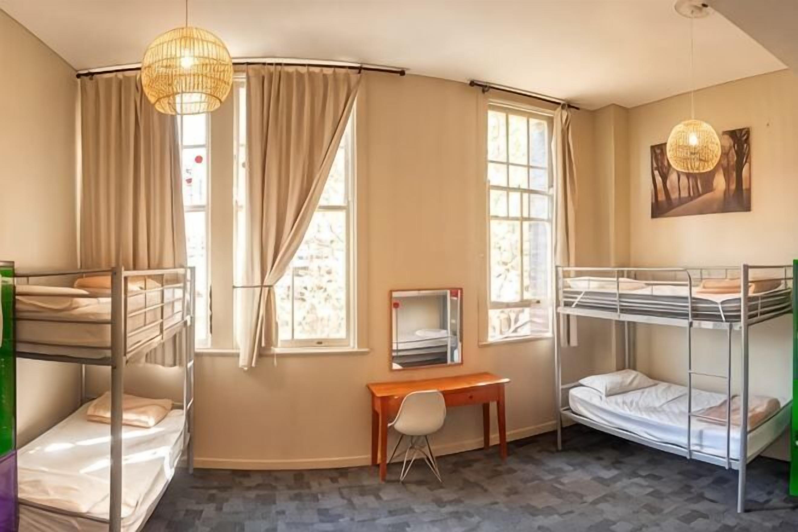 Een kamer met stapelbedden, een bureau, een stoel en een televisie.