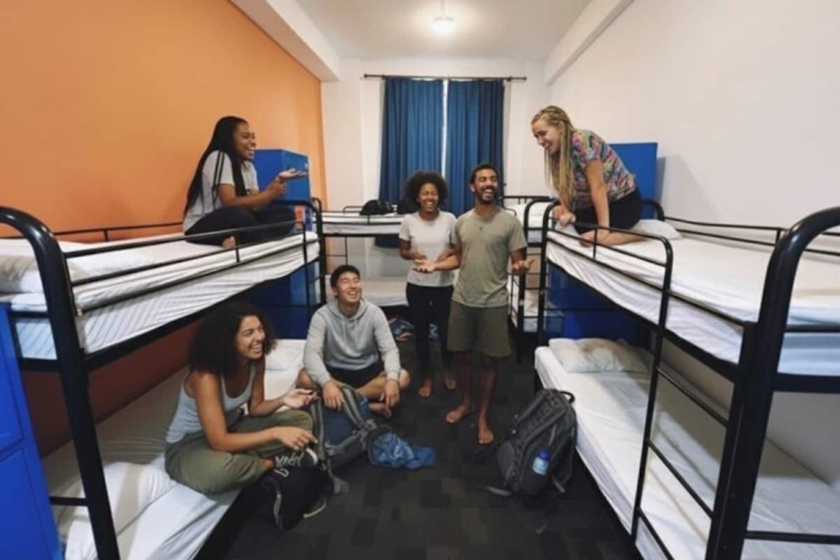 Un dormitorio con literas, una pared azul y una ventana con cortinas.