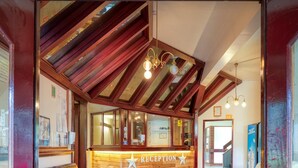 A reception area with a wooden reception desk, a leather couch, and a star logo. - Snowy Gums (Smiggin Holes)