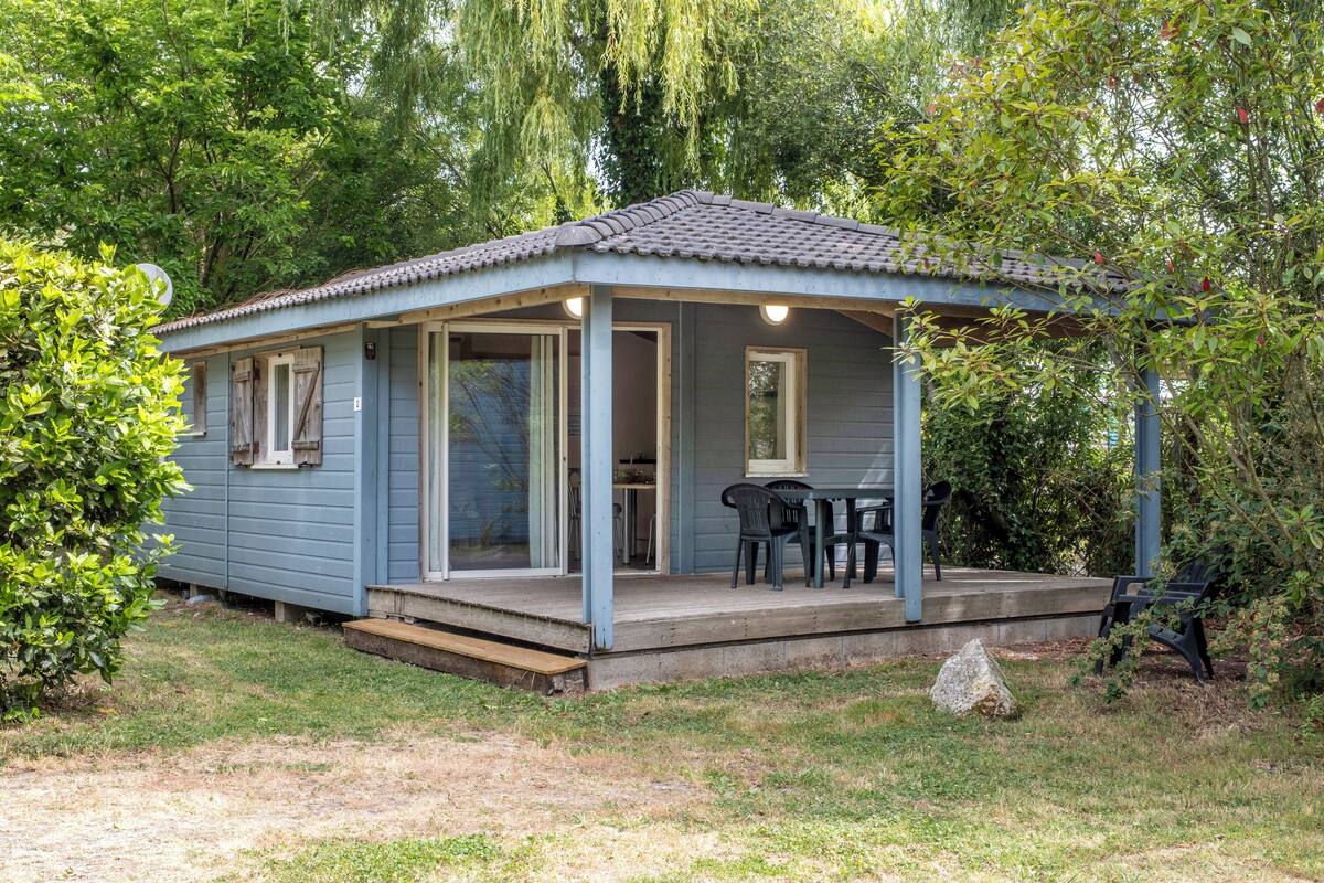 A small, single-story building with a porch and outdoor seating area.