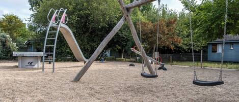 A playground with a slide, swings, and a climbing structure.