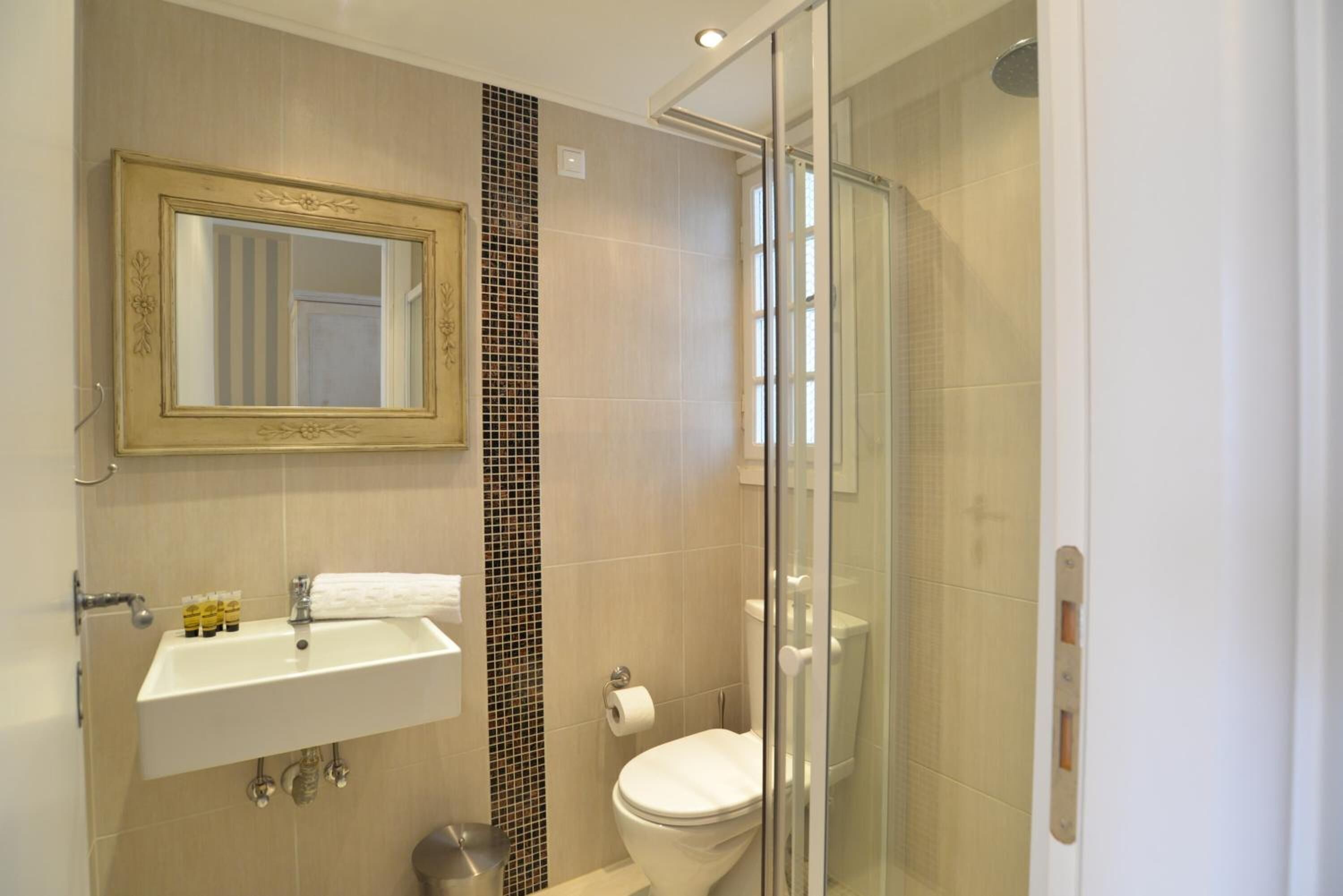 A modern bathroom with a sink, toilet, and glass-enclosed shower.