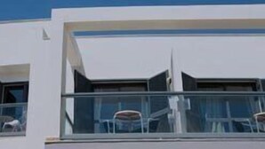 A modern building with a balcony and large windows. - La Posada de Paco (Nijar)