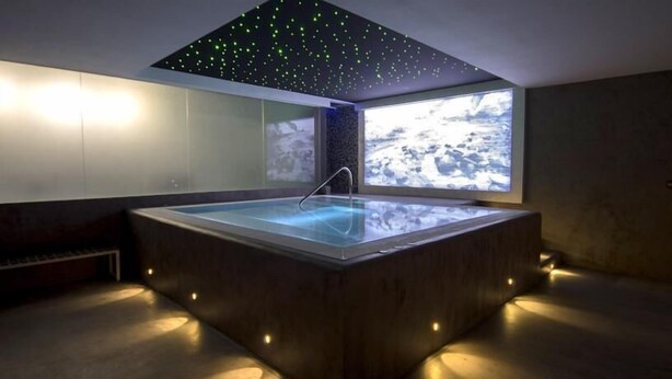 A modern spa room with a rectangular hot tub, a starry ceiling, and a large window overlooking a rocky landscape. - La Posada de Paco (Nijar)