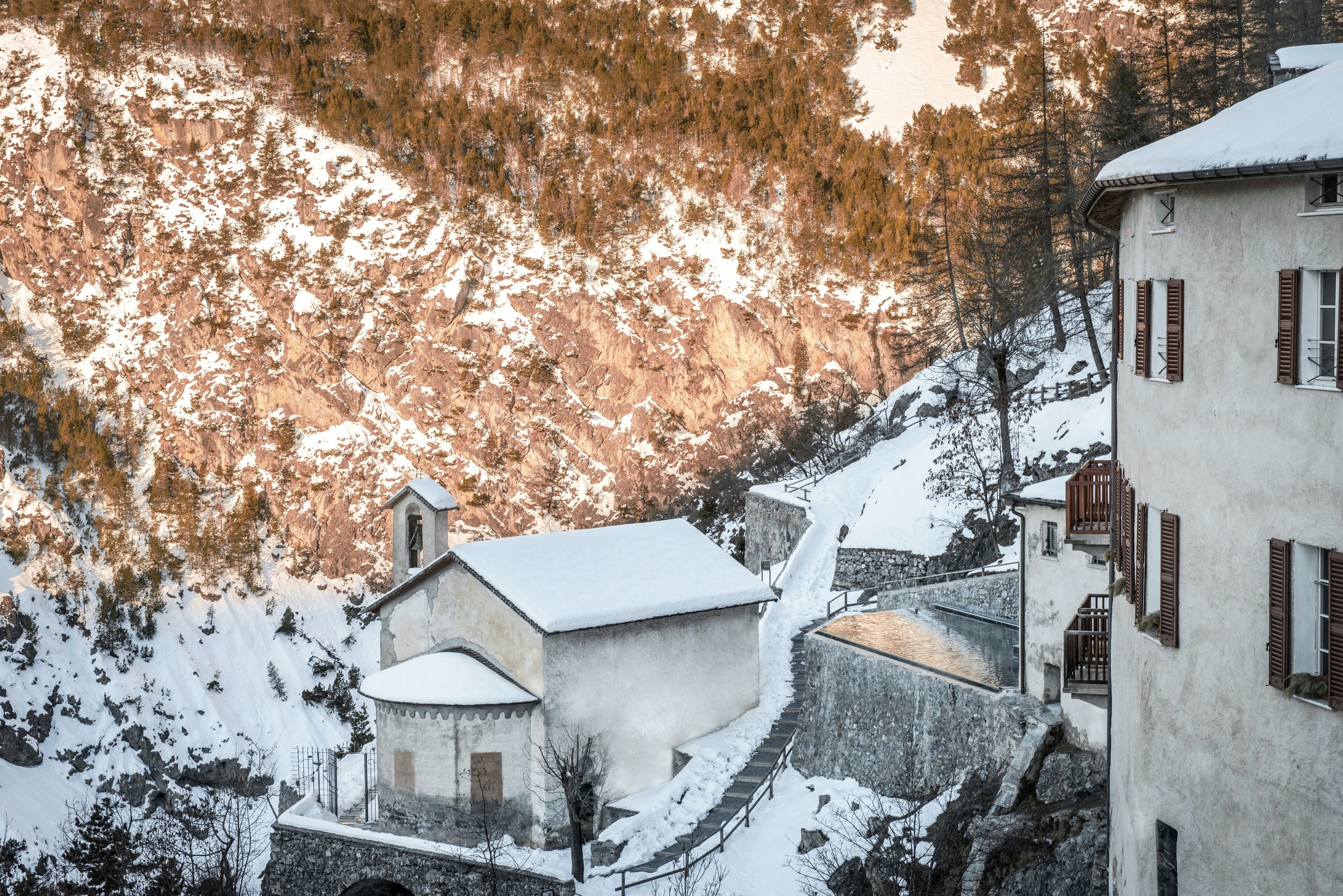 Ein schneebedecktes Gebäude mit einer steilen Steintreppe, die zu ihm hinaufführt.