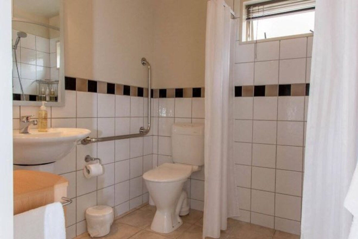 A bathroom with a toilet, sink, and shower.