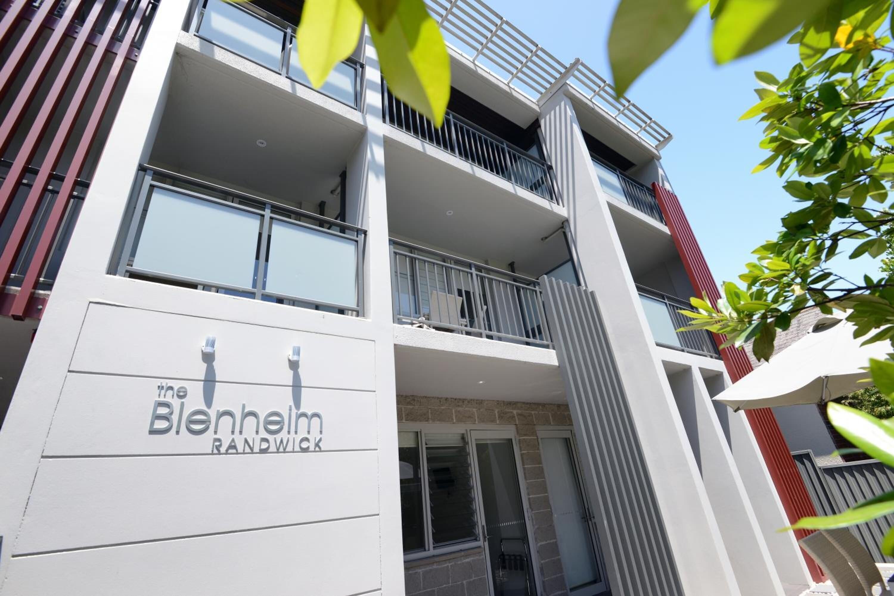 A multi-story hotel with balconies and a sign reading 'The Blenheim Randwick.'