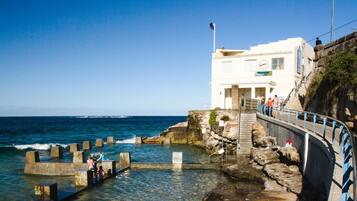 Un edificio costero con una escalera que conduce a una plataforma con vistas al mar.