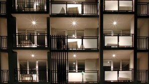 Un edificio de varios pisos con balcones, cada uno iluminado por una luz brillante.