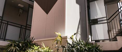 Un edificio de varios pisos con un marcado elemento vertical, balcones y escaleras.