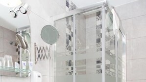 Un baño moderno con ducha de vidrio, lavabo de vidrio y un inodoro.