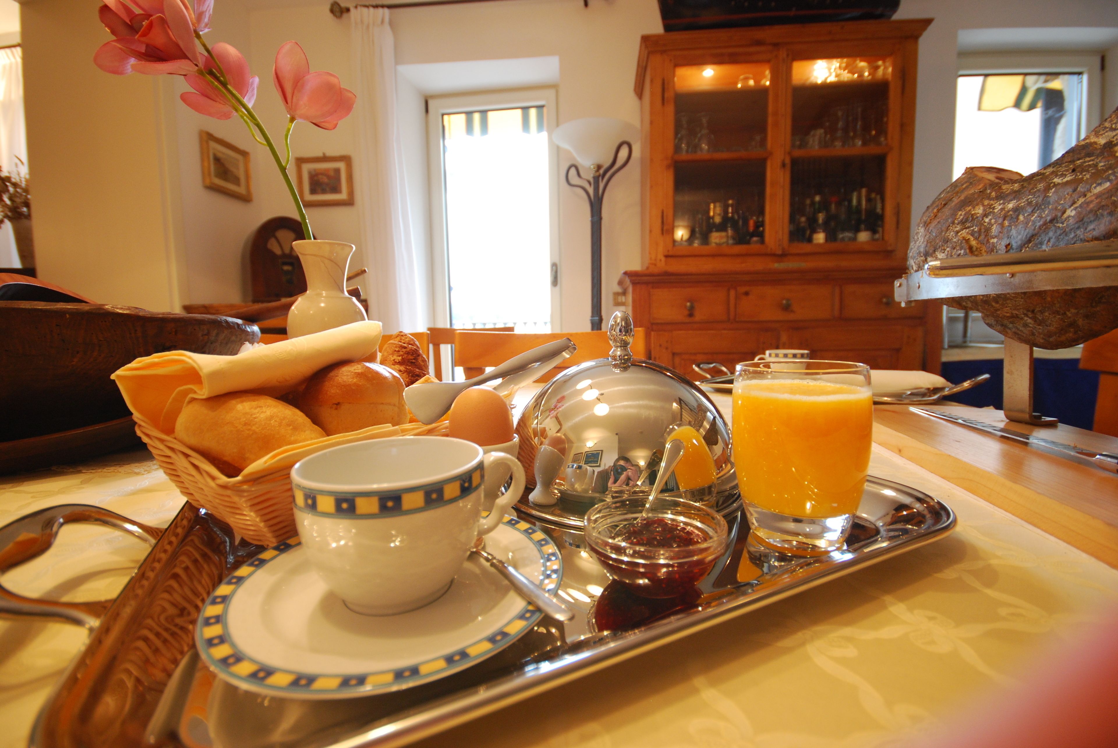 A breakfast tray with bread, eggs, a cup, and orange juice.