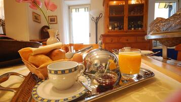 A breakfast tray with bread, eggs, a cup, and orange juice.