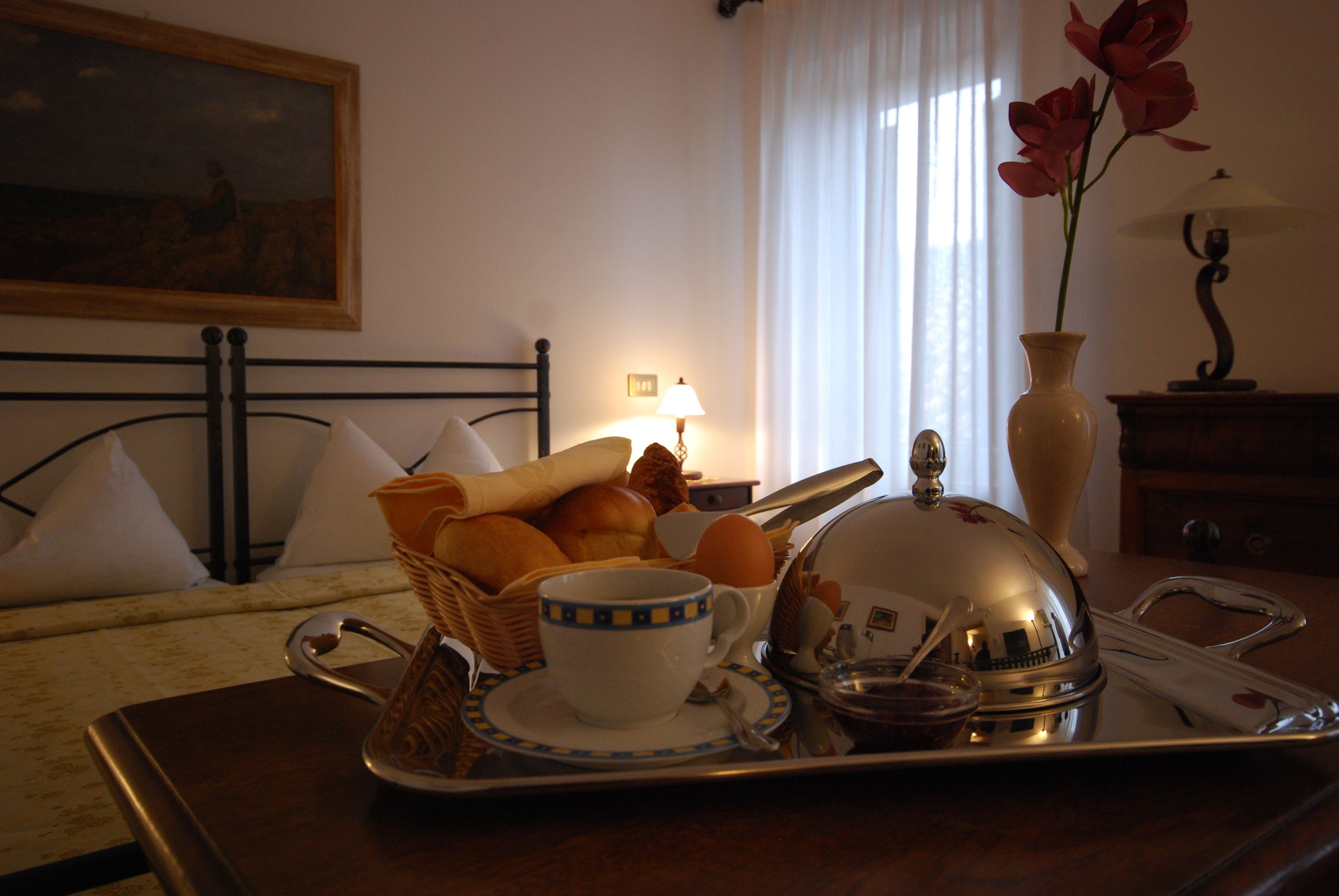Ein Frühstücksbrett mit Brot, Eiern und einer Tasse auf einem Holztisch im Hotelzimmer.