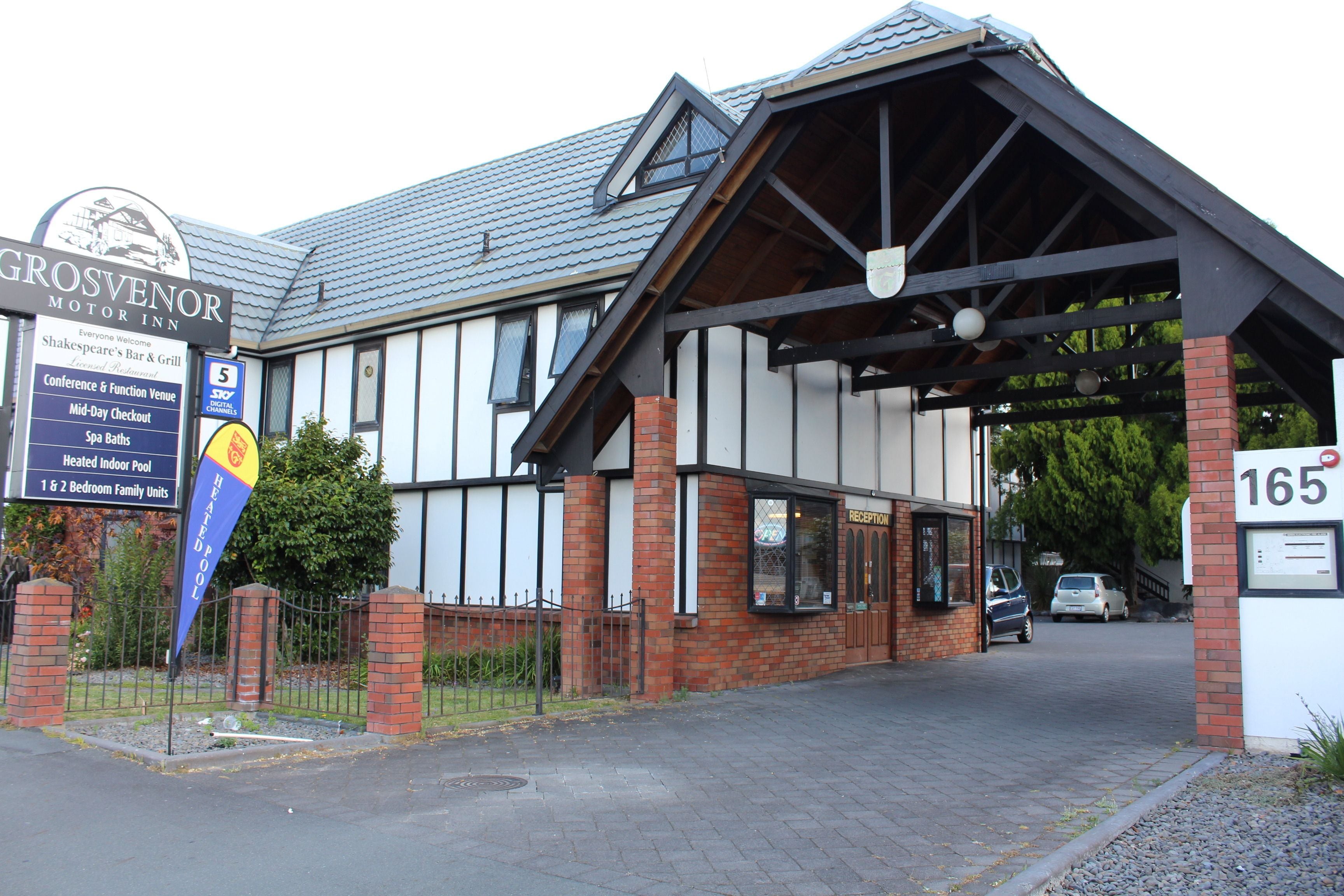 A building with a sign for Grosvenor Motor Inn, indicating it is a conference and function venue, spa baths, heated indoor pool, and 1 & 2 bedroom family units.