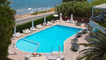 Een buitenzwembad, parasols voor strand/zwembad