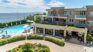 Un hotel moderno con piscina, zona de estar al aire libre y vista al mar.