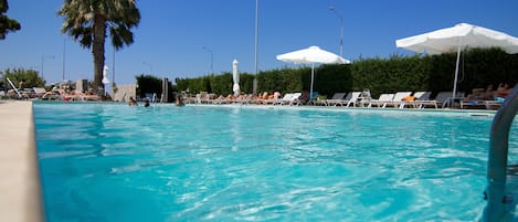 Piscine extérieure, parasols de plage, chaises longues