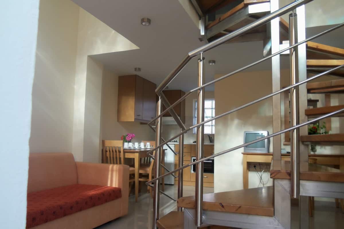Un interior moderno con una escalera, un comedor y un sofá.