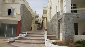 Un immeuble résidentiel doté d’un escalier central, d’une façade en pierre et de nombreux balcons.
