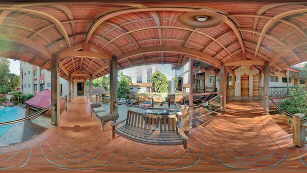 Un espacio al aire libre cubierto con piscina, asientos y una escalera que conduce a un nivel superior.
