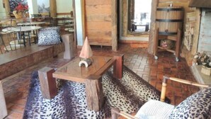 Un interior rústico con una mesa de madera, un tapete de estampado de leopardo y un comedor con sillas y una mesa.