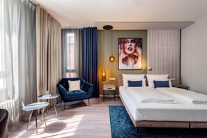 A hotel room with a bed, a desk, a chair, and a painting on the wall. - Aspire Elements Reutlingen, Trademark Collection by Wyndham (Reutlingen)