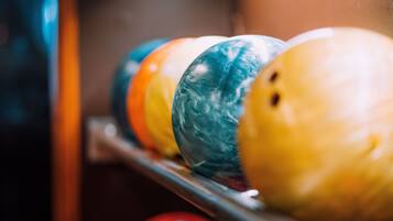 A row of bowling balls on a rack.