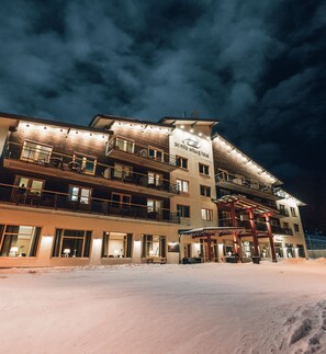 A multi-story hotel with a snow-covered ground, balconies with railings, and a sign indicating it is the Carinthia Wilis Hotel. - Pernilla Wiberg Hotel (Idre)
