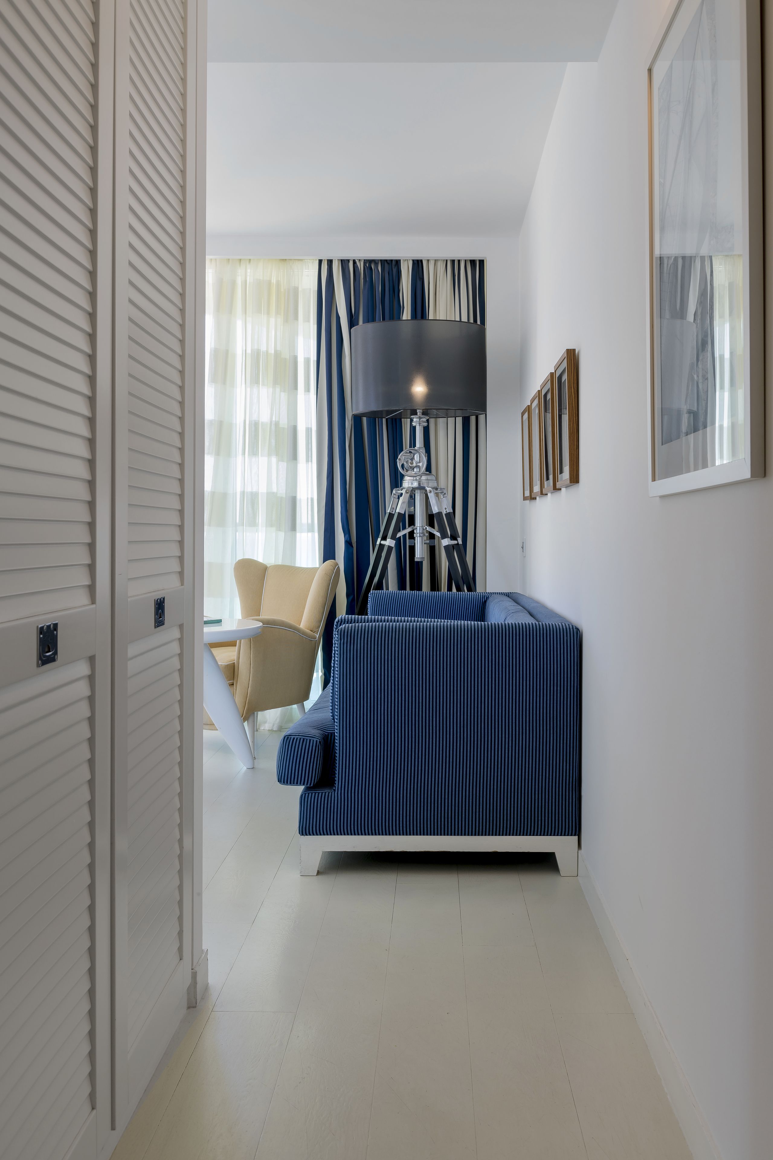 Una habitación moderna con un sofá, una lámpara trípode y una silla.