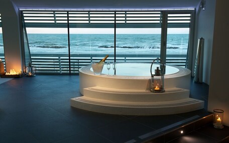 Un área de spa con un jacuzzi circular y vistas al océano.