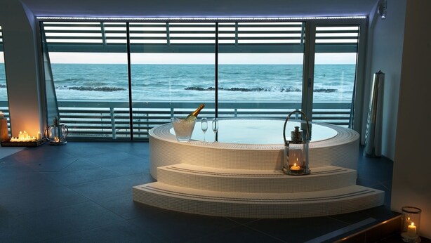 Un área de spa con un jacuzzi circular y vistas al océano.