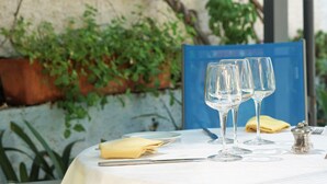 Taula preparada per dinar amb vasos de vi buits, un cam a plicat i un salabotre.