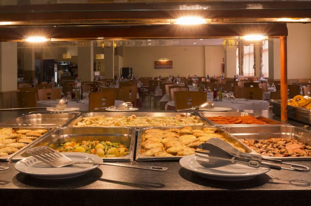 Una mesa de buffet con diversos alimentos y utensilios.