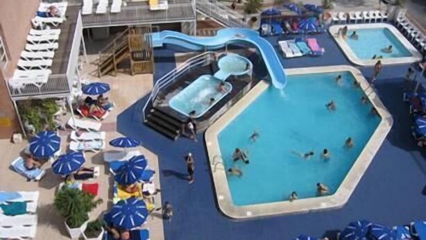 Ein Poolbereich auf dem Dach mit mehreren Pools, Liegestühlen und Sonnenschirmen.