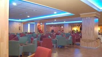 A hotel lobby with rows of seating, a reception area, and a decorative wall.