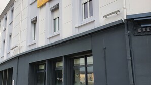 Een hotelgebouw met meerdere 'HOTEL' borden, een 'HOTEL ACCESS' bord en een 'GES' logo op de ramen.