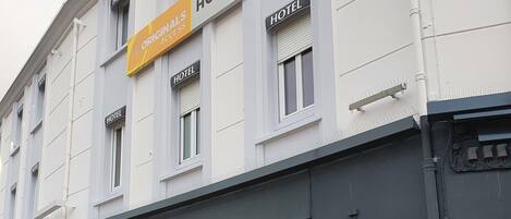 Hotellirakennuksessa on useita «HOTEL»-kylttejä, «HOTELIN SISÄÄNKÄYNTI»-kyltti ja «GES»-logo ikkunoissa.