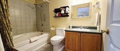 A bathroom with a bathtub, toilet, and sink.