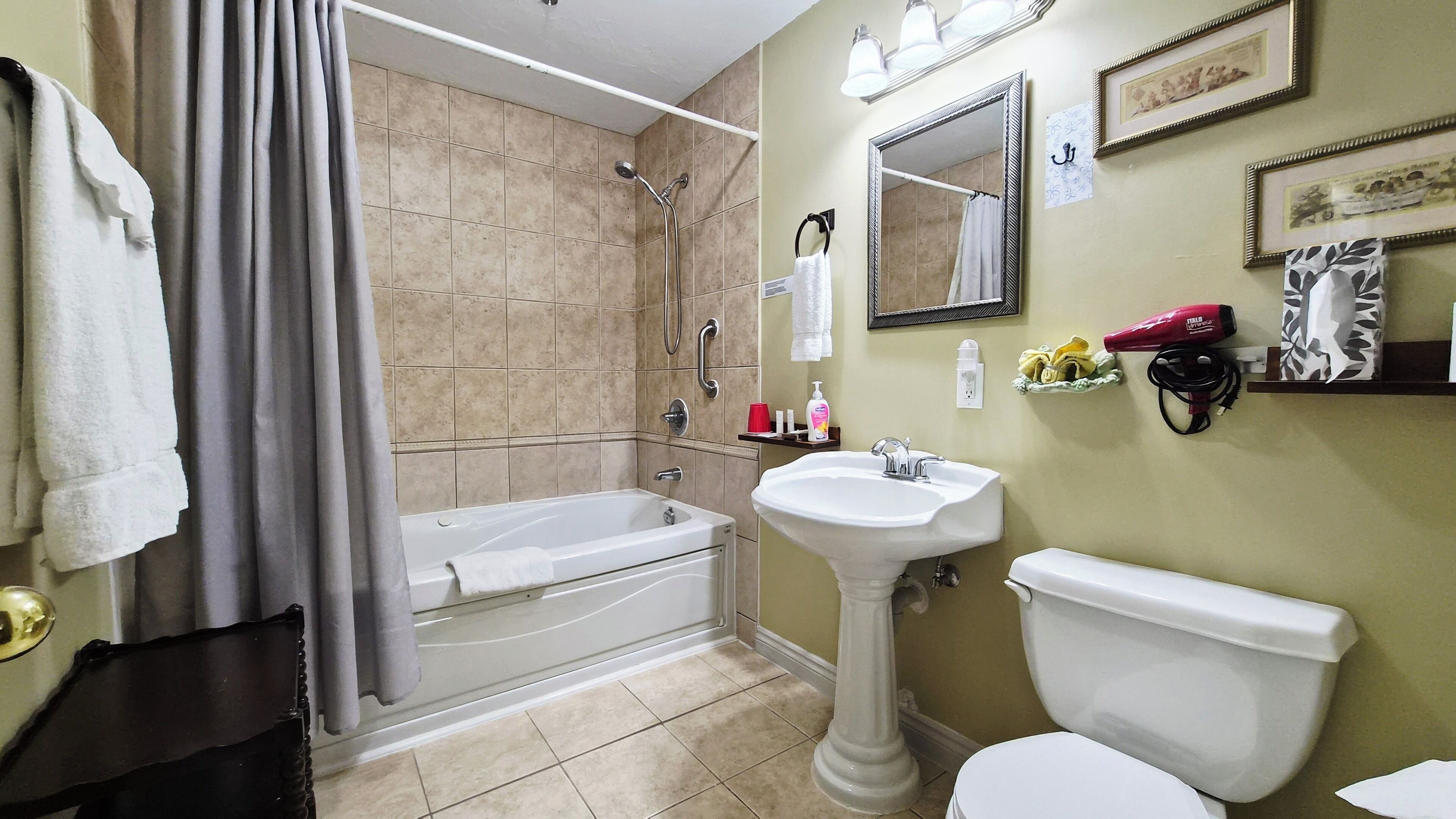 Un baño con bañera, lavamanos e inodoro.