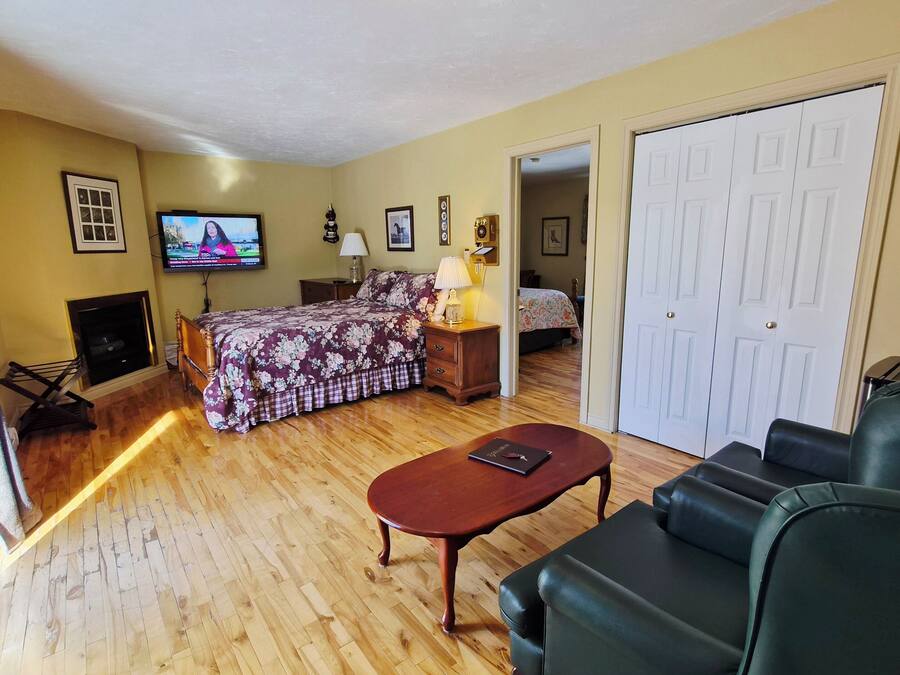 A room with a bed, a TV, a desk, a chair, and a door.