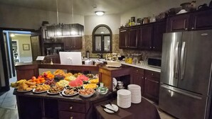Una cocina con isla central, armarios de madera, refrigerador de acero inoxidable y salpicadero de azulejos.