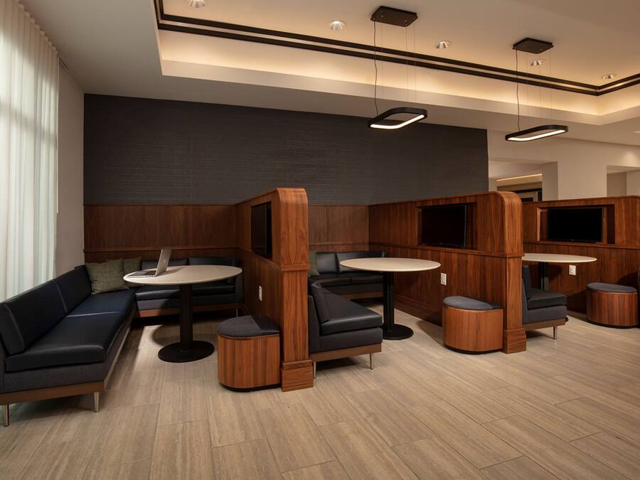 A modern interior with a sectional sofa, round tables, and built-in wooden cabinets.
